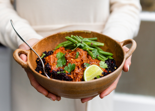 NUUDA chicken Tikka Masala dish with a side of green beans - being held in a beautiful brown bowl. 