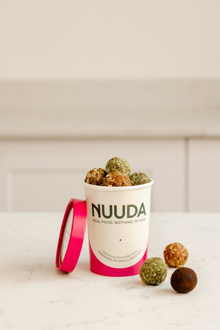 NUUDA snack balls in a branded container on a white surface